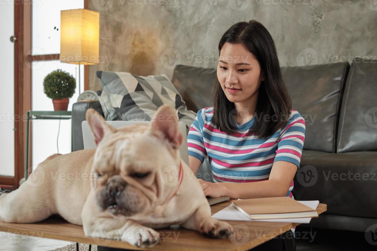 casual freelance asiática fofa mulher trabalhando em casa com o cachorro dela. foto