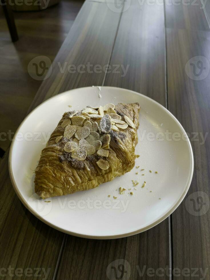 fresco cozido amêndoa croissant e café café da manhã foto