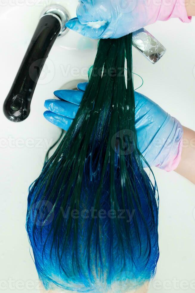 maior ângulo tiro do cabeleireiro lavagens do cliente cabeça com grandes cabelo safira cor depois de cabelo tingimento processo foto