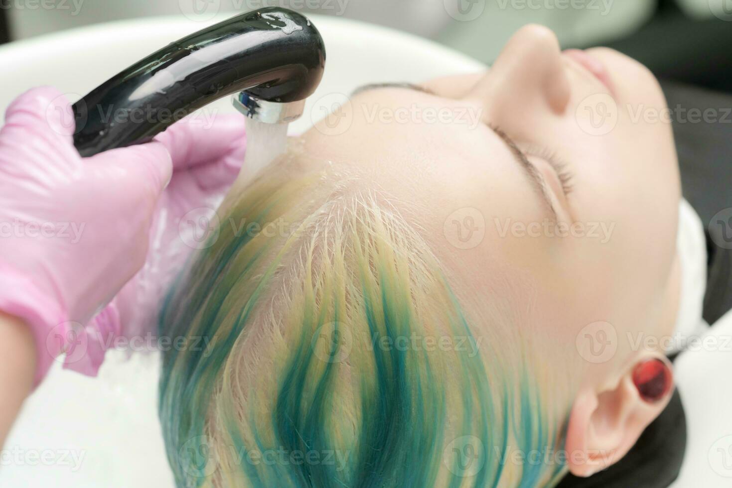 profissional cabelo salão, estilista de cabelo lavando cliente cabeça com verde cabelo cor foto