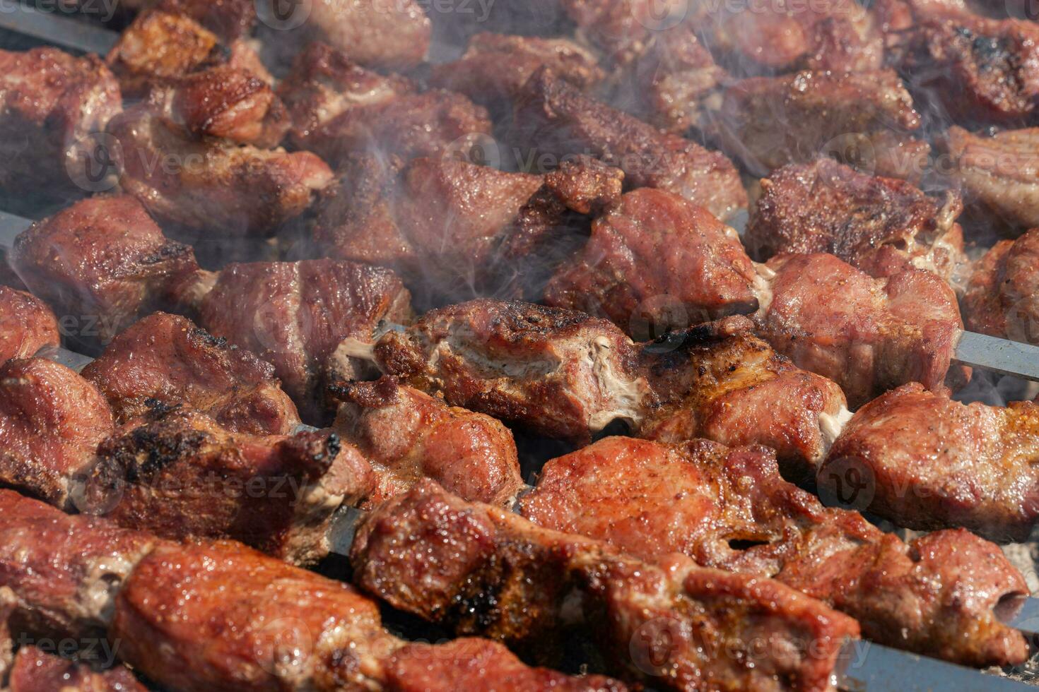 churrasco cozinhando em espetos em carvão grade com fumaça. fechar-se Visão foto