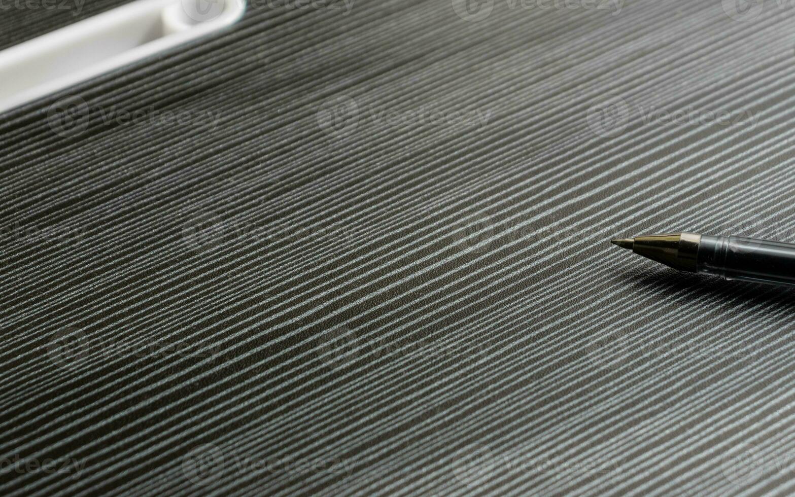 uma caneta em uma de madeira texturizado mesa com parcial sombras, depois de alguns Editar% s. foto