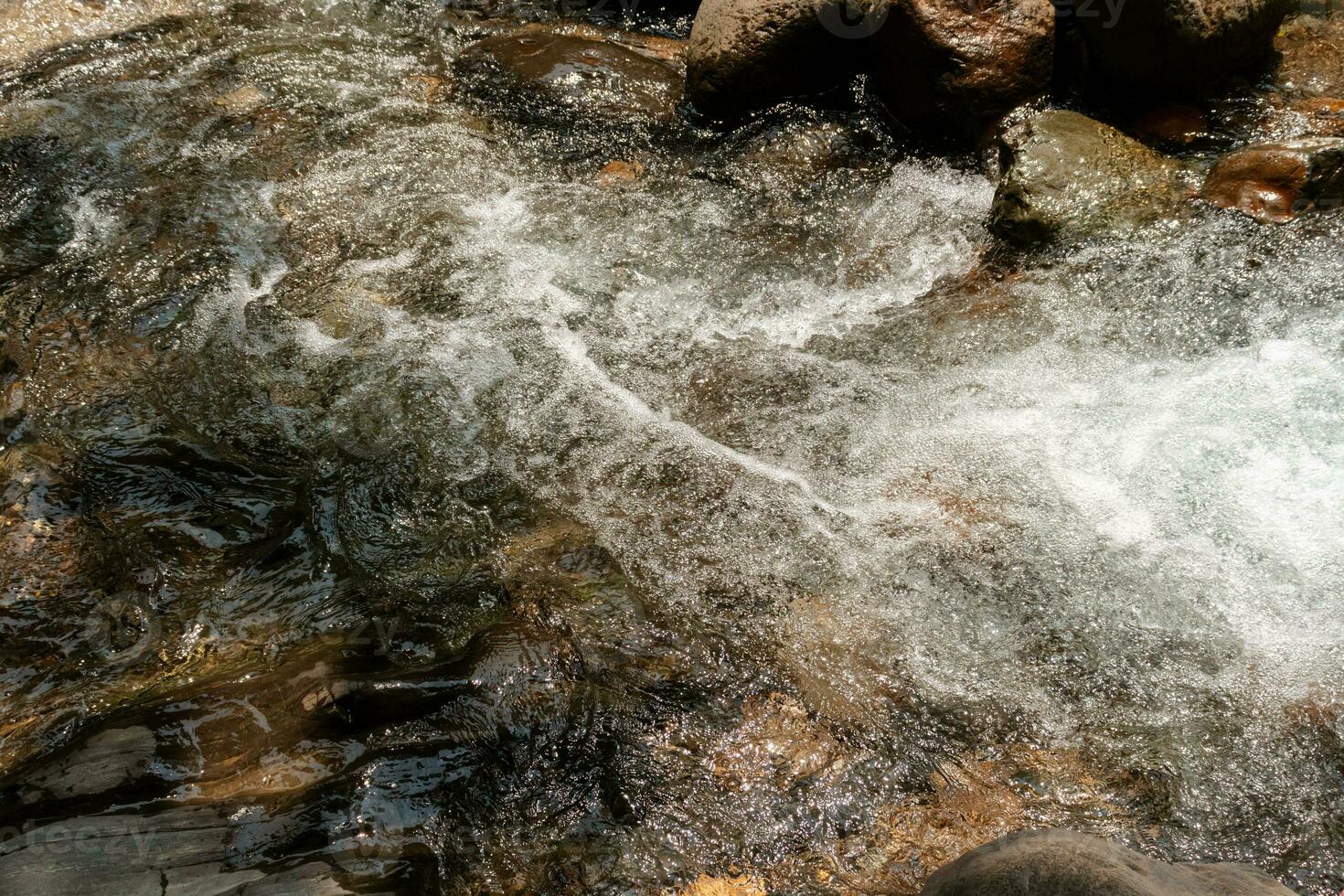 água fluindo sobre pedras dentro uma fluxo, depois de alguns Editar% s. foto