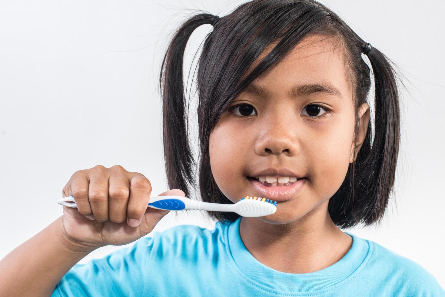 menina escovando os dentes em estúdio tiro. foto