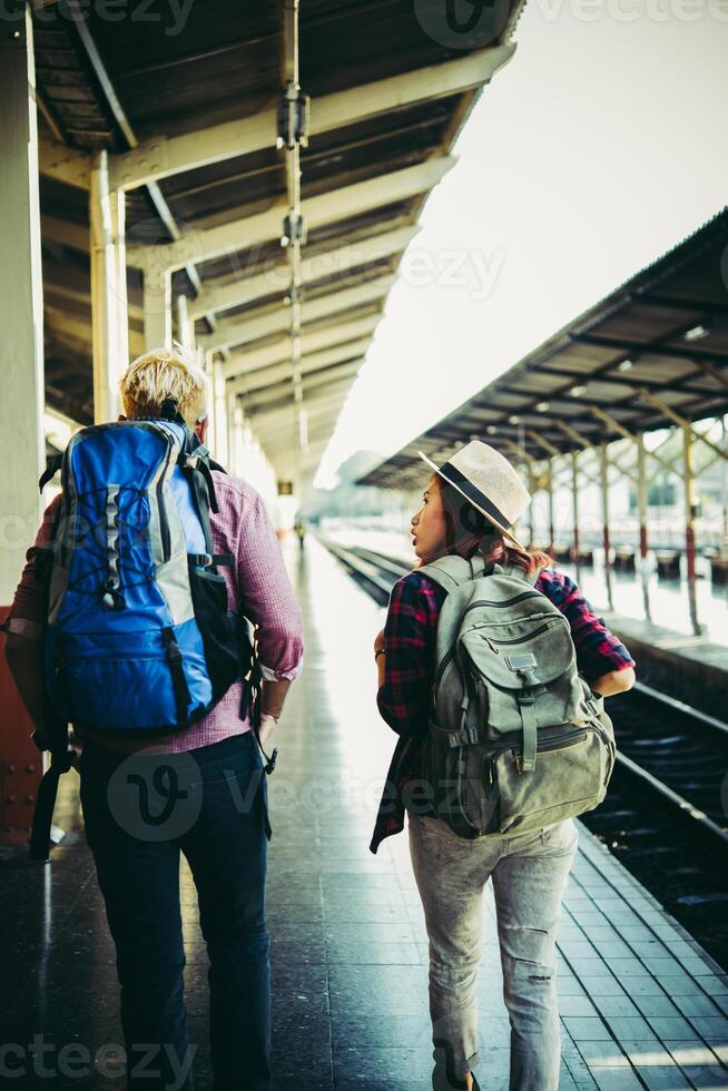 casal jovem hippie na estação de trem. foto