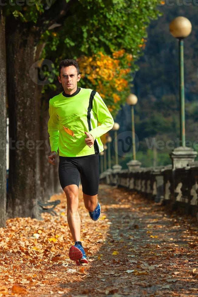 homem atleta corre em treinamento no outono foto