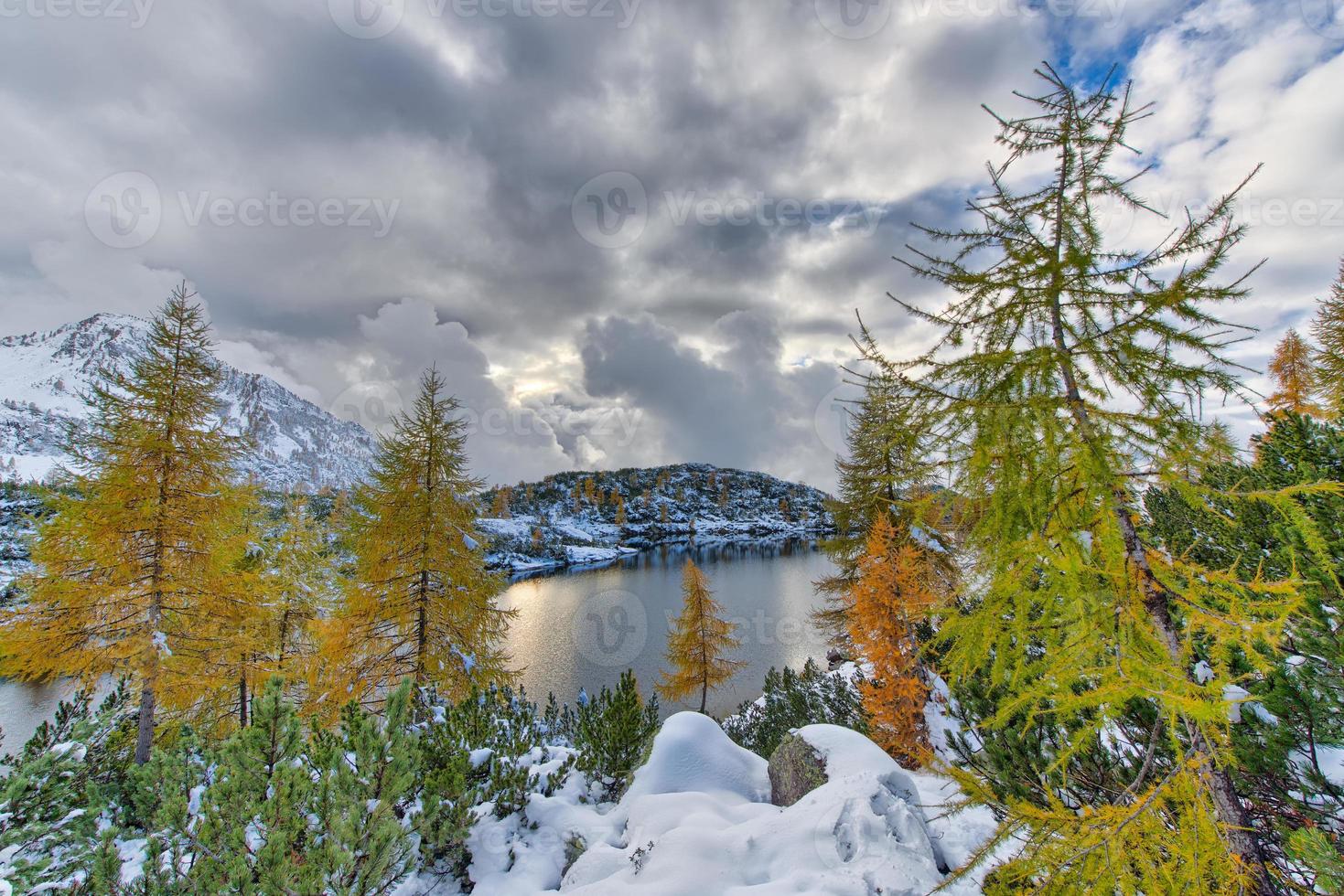 lago alpino no outono com a primeira neve foto