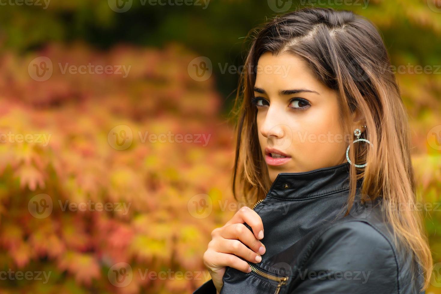 retrato de uma linda jovem com um fundo de folhas de outono foto