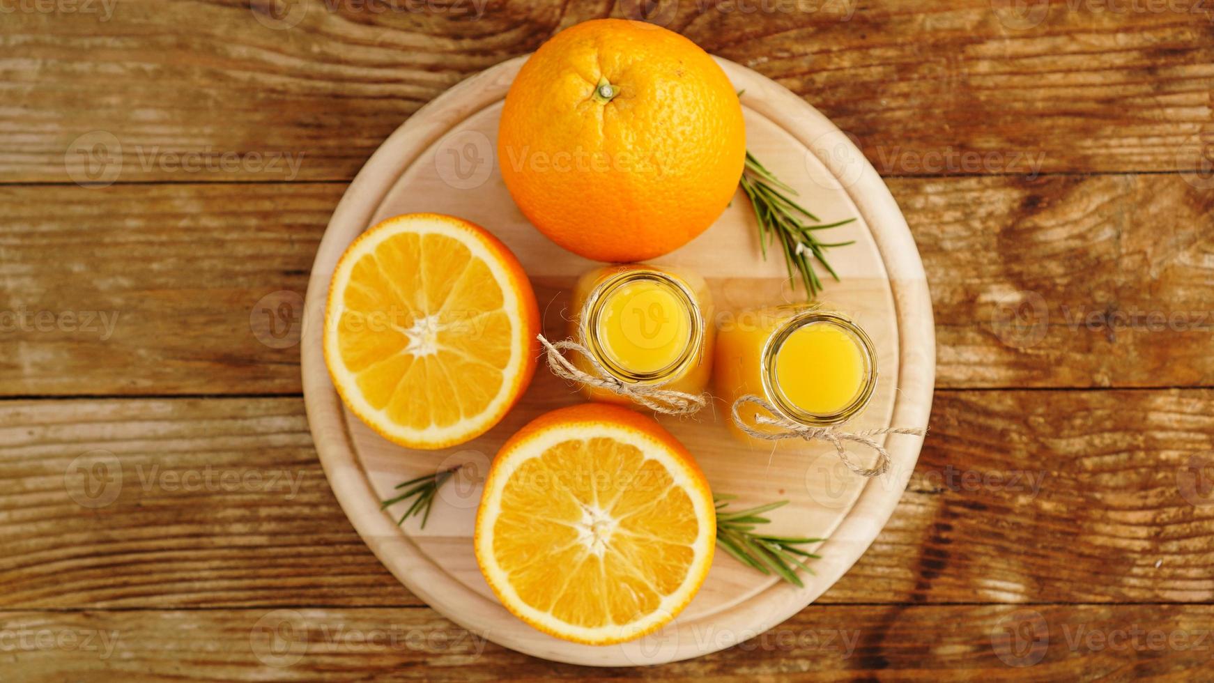 suco de laranja fresco na mesa de madeira em uma placa de madeira foto