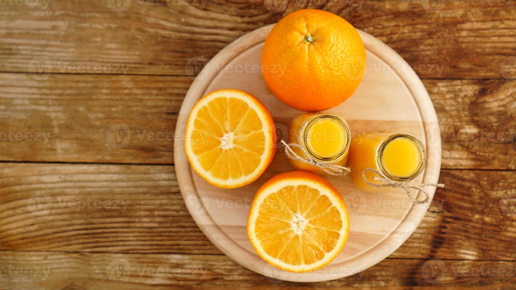 suco de laranja fresco na mesa de madeira em uma placa de madeira foto