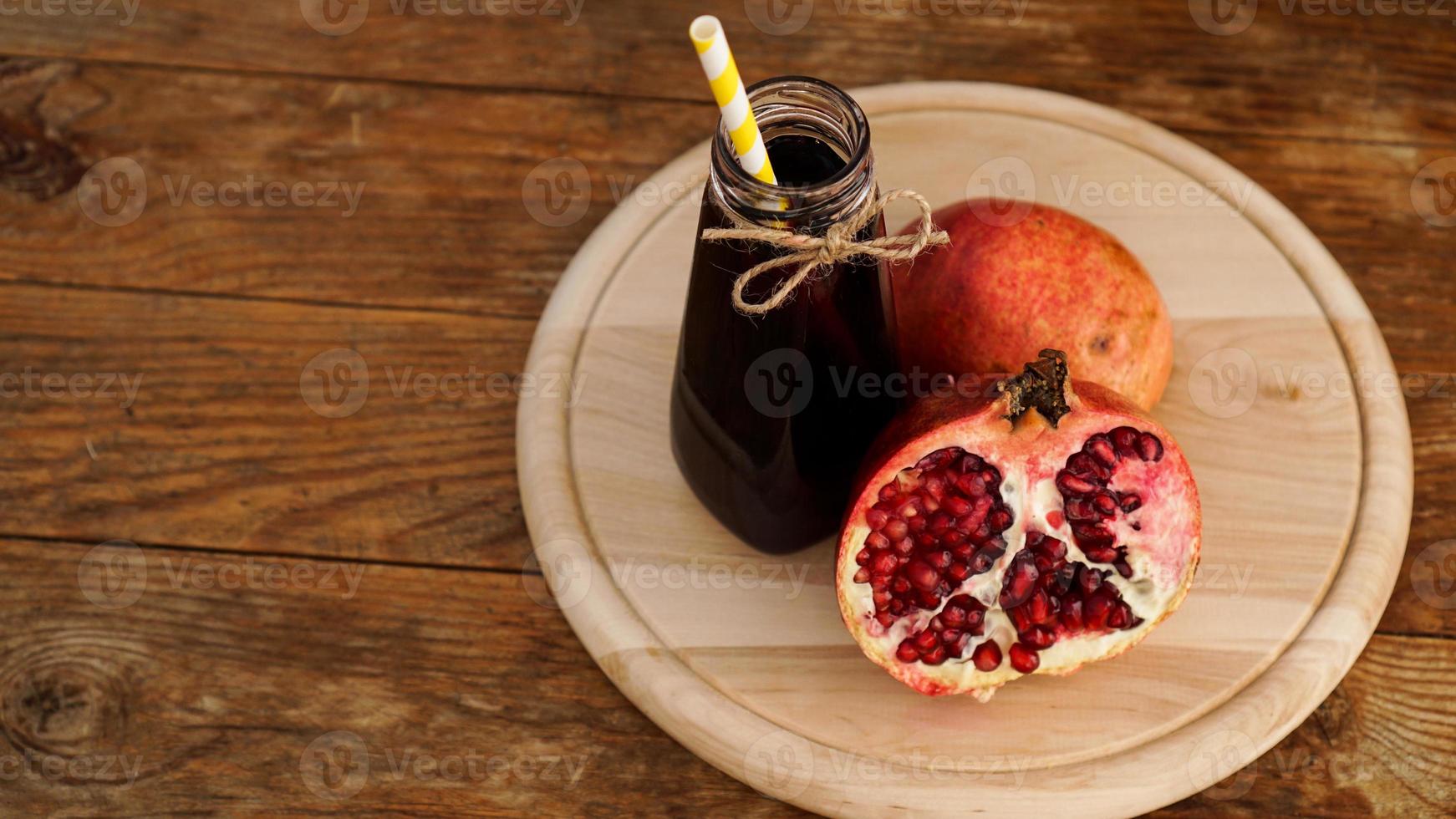 romãs maduras com suco em fundo de madeira. foto