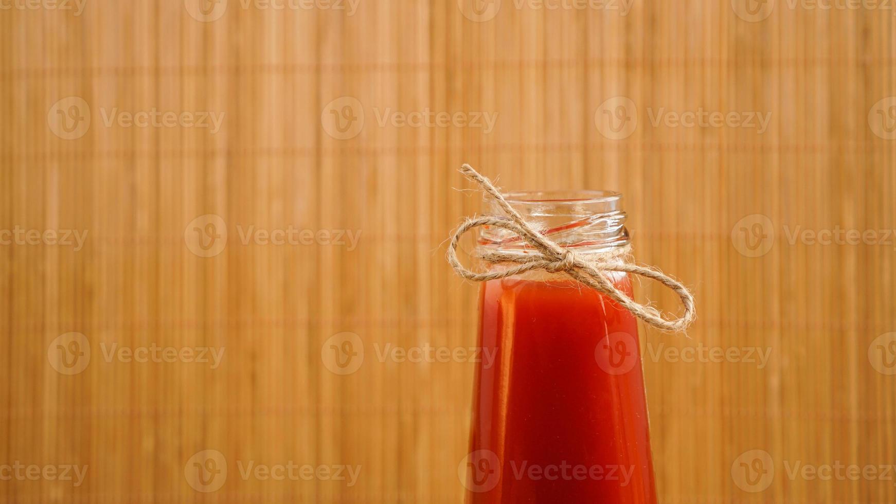 garrafa de suco de tomate em fundo de madeira foto