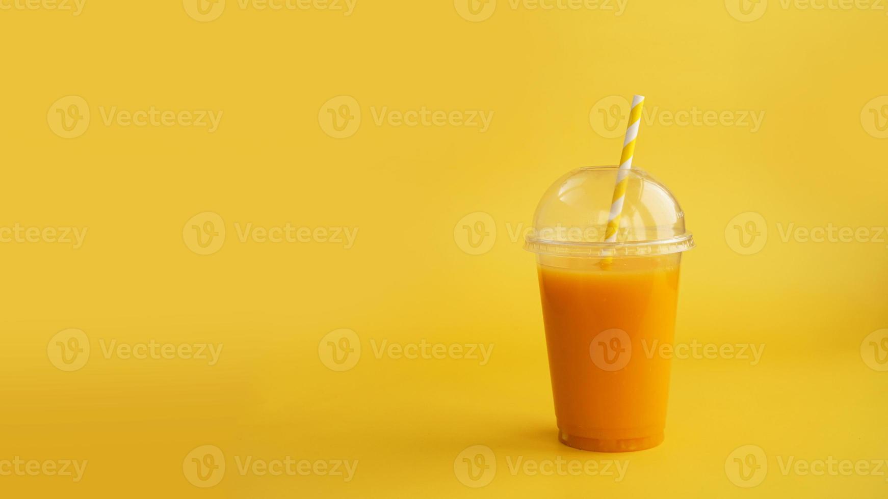 um copo de plástico com suco de laranja. suco natural ou smoothies. foto