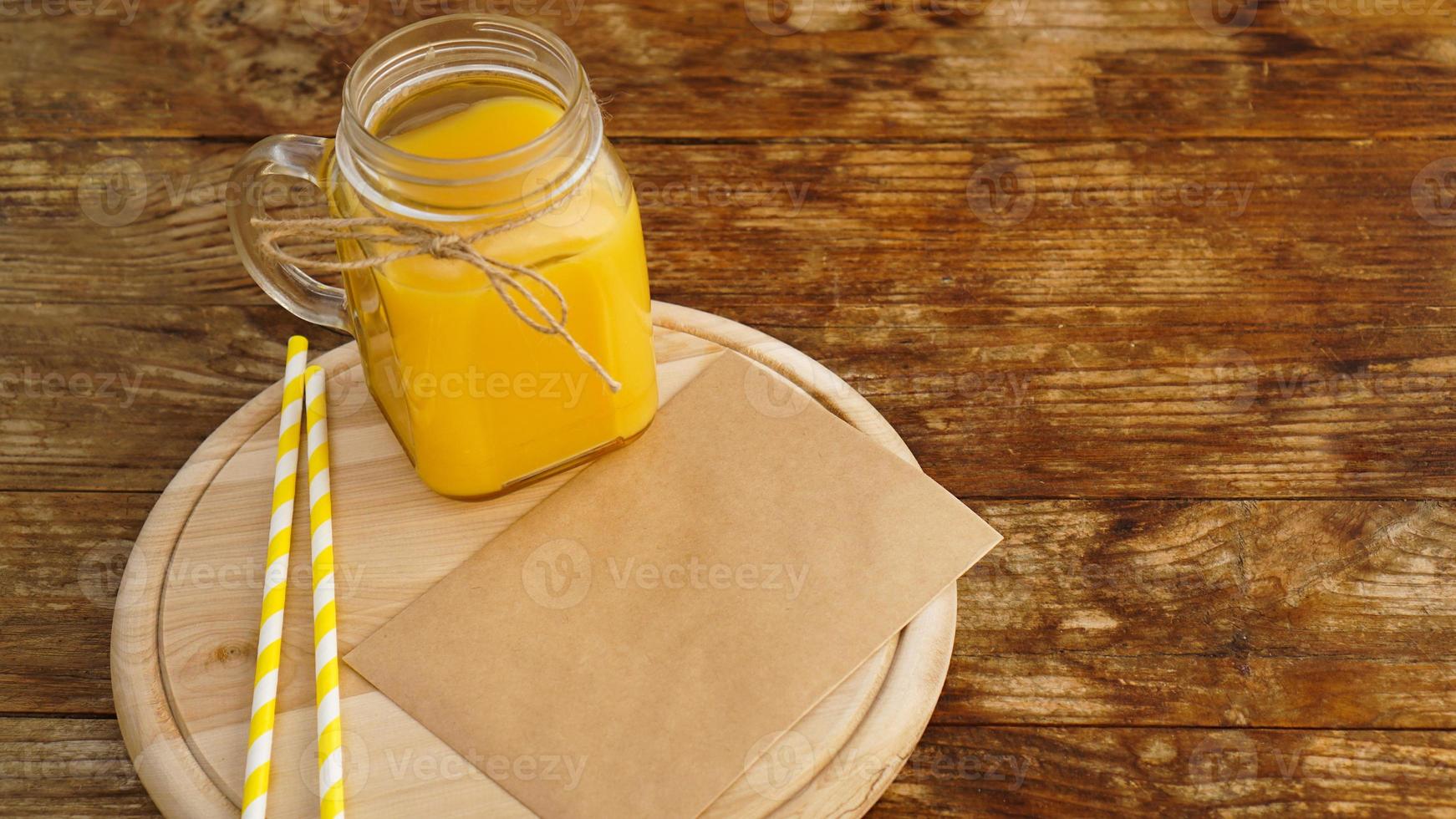 suco de laranja em uma jarra de vidro sobre um fundo de madeira foto