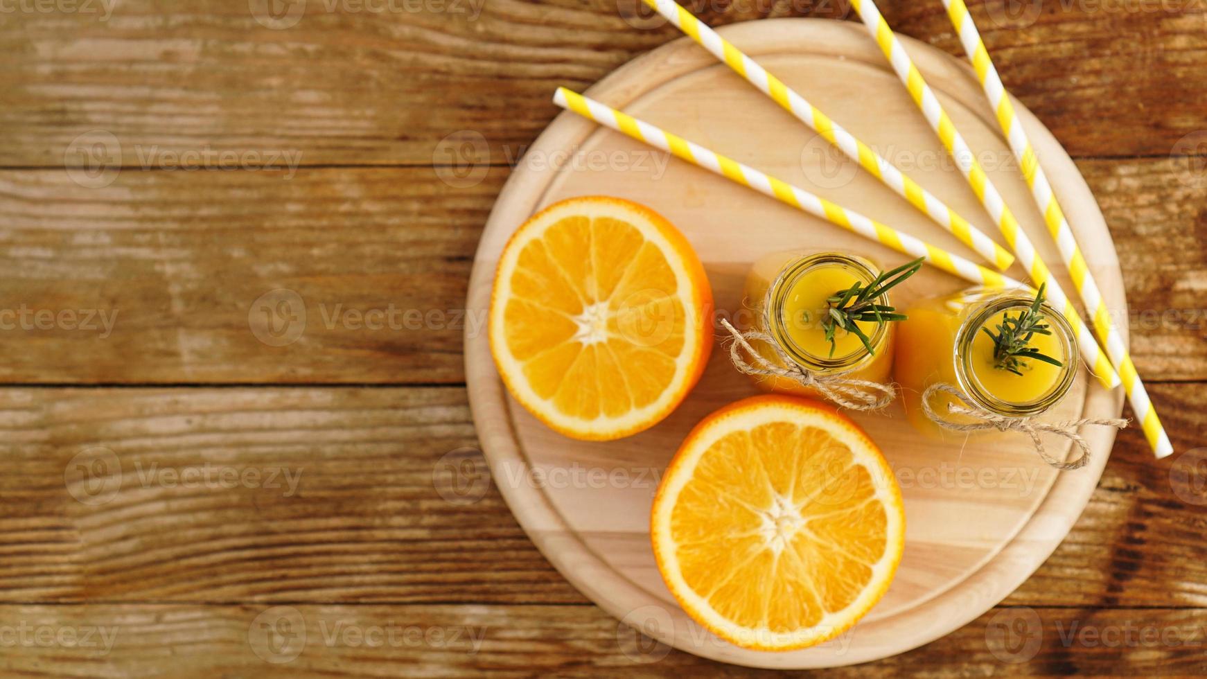 suco de laranja em garrafas de vidro. o suco é decorado foto