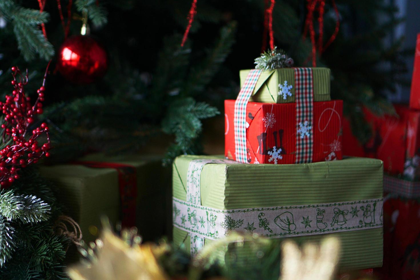lindas caixas de presente de natal verdes e vermelhas sob a árvore de natal foto