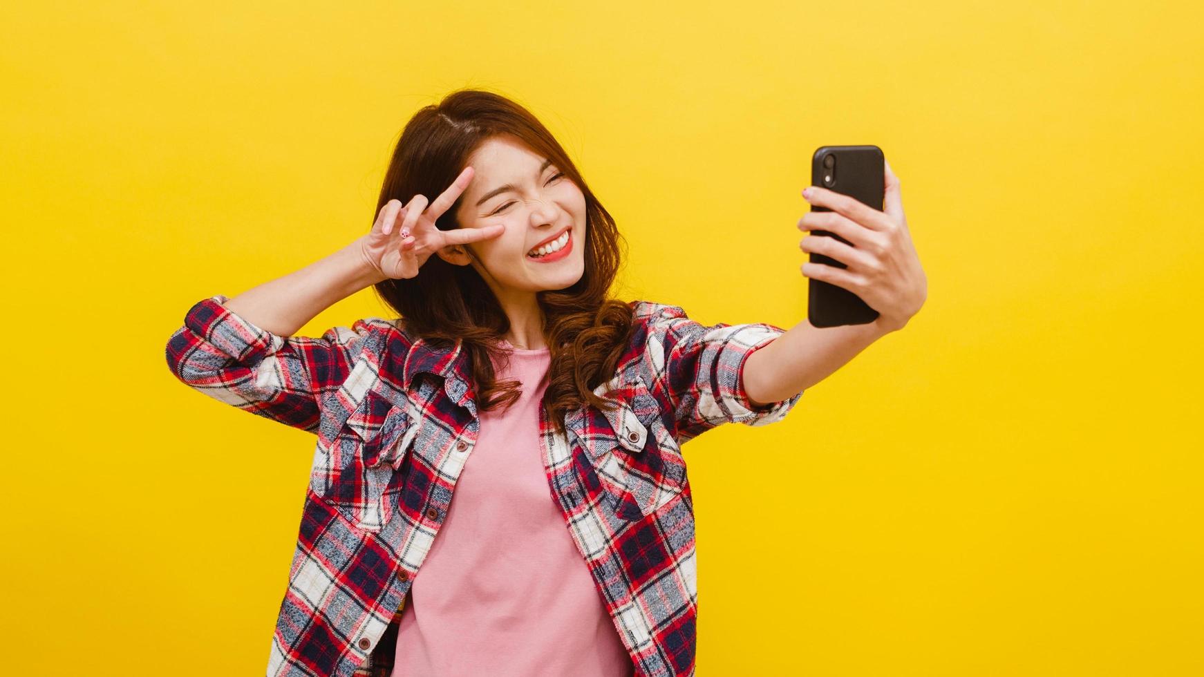 mulher asiática fazendo foto de selfie no telefone com expressão positiva.