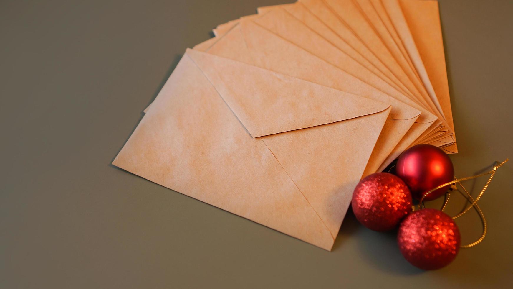 composição de natal. envelopes artesanais e bolas vermelhas foto