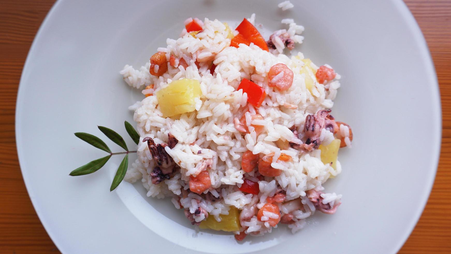 arroz com camarão e abacaxi, comida tailandesa em prato branco foto