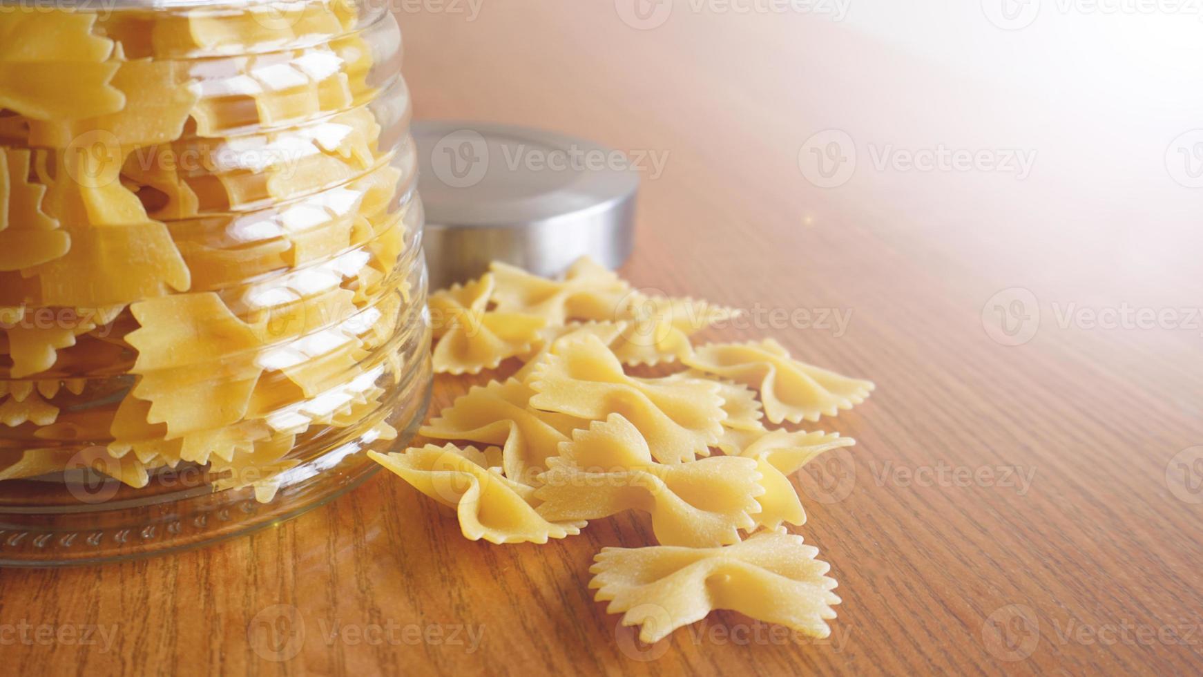 macarrão em forma de laços espalhados de jarra de vidro foto