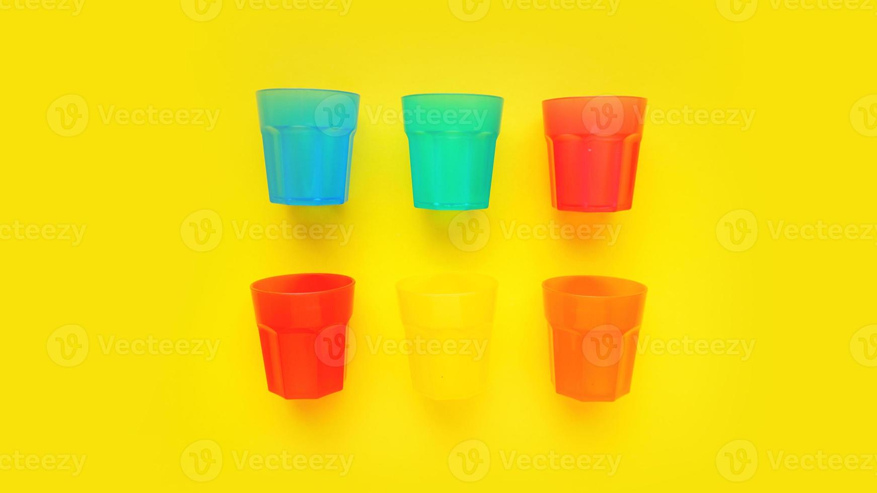 vidro plástico de várias cores isolado em fundo amarelo foto