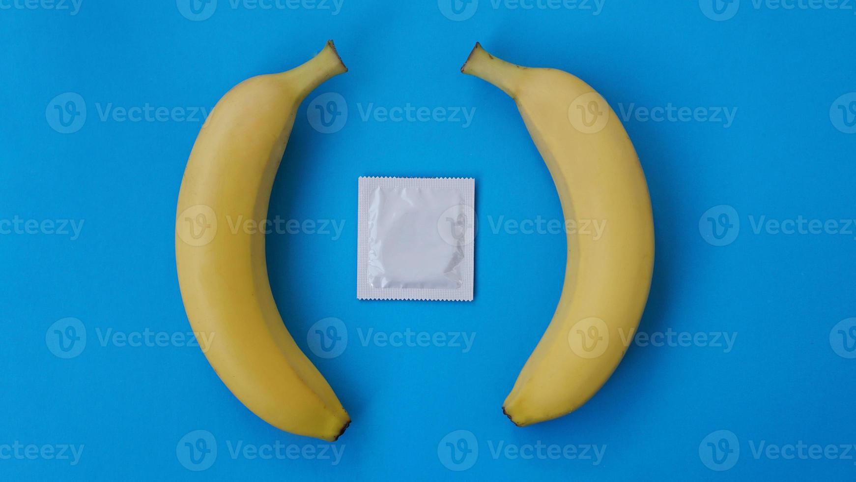 preservativos e duas bananas juntas, conceito de contraceptivos foto