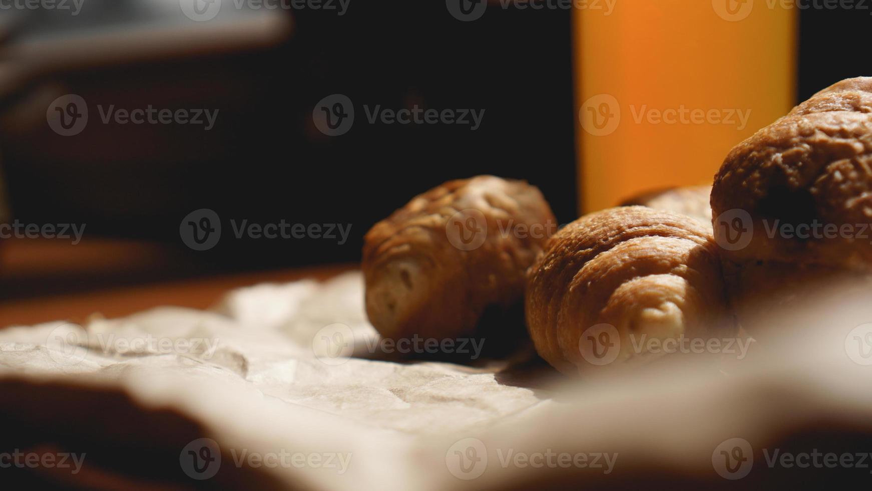 croissants fresquinhos com suco de laranja em papel kraft foto