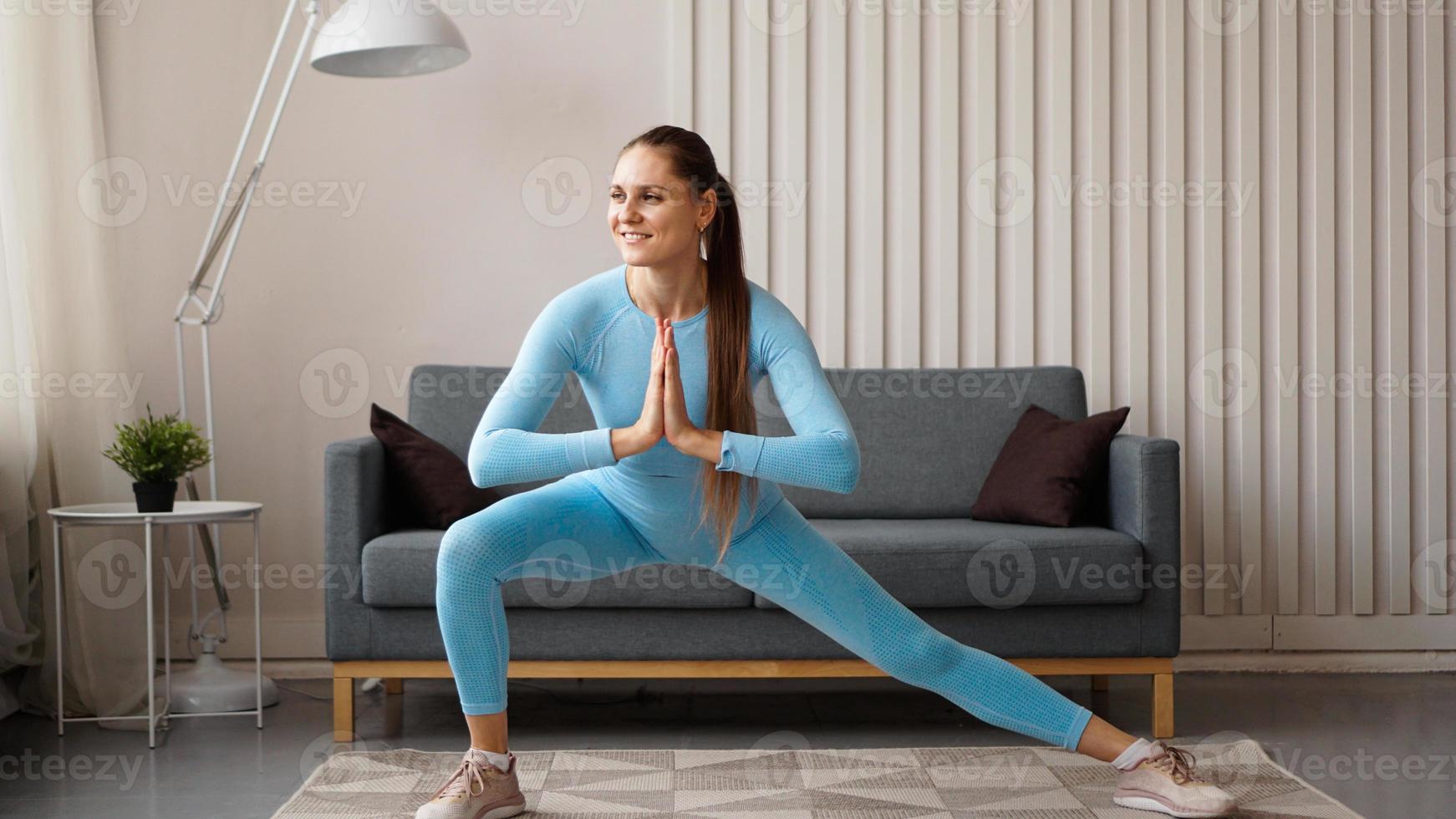 jovem determinada mulher magra confiante fazendo exercícios em casa foto