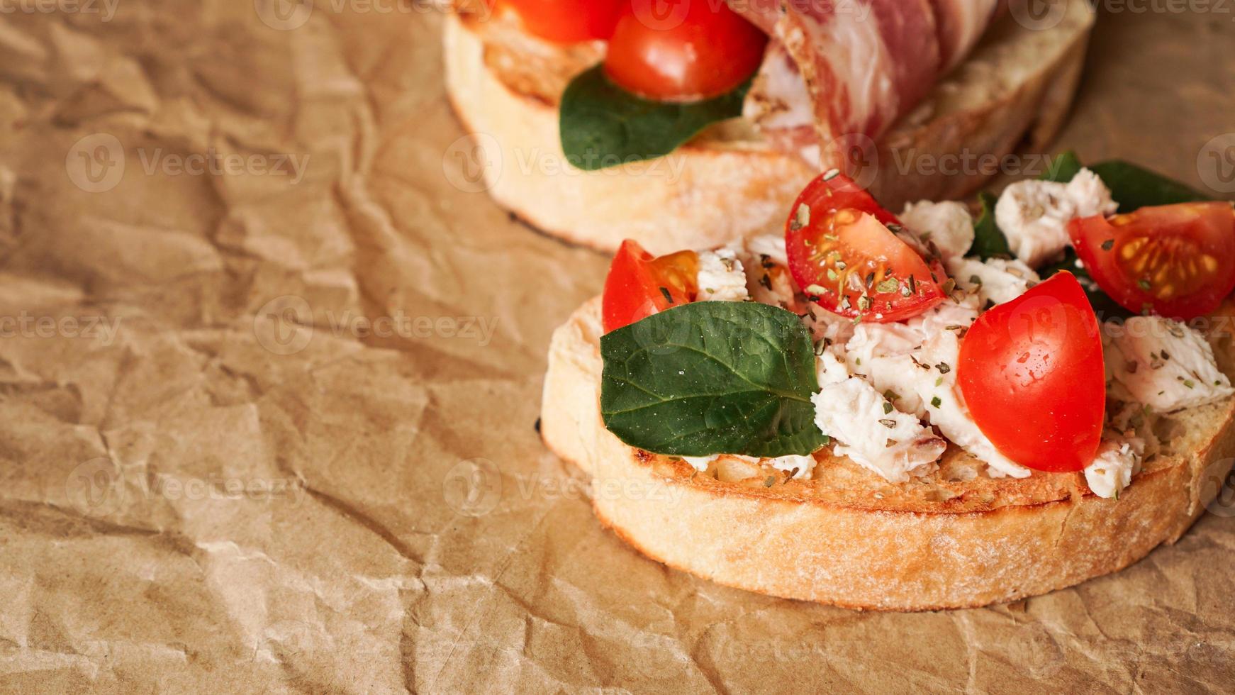 três bruschettas frescas em papel artesanal. lanche delicioso foto