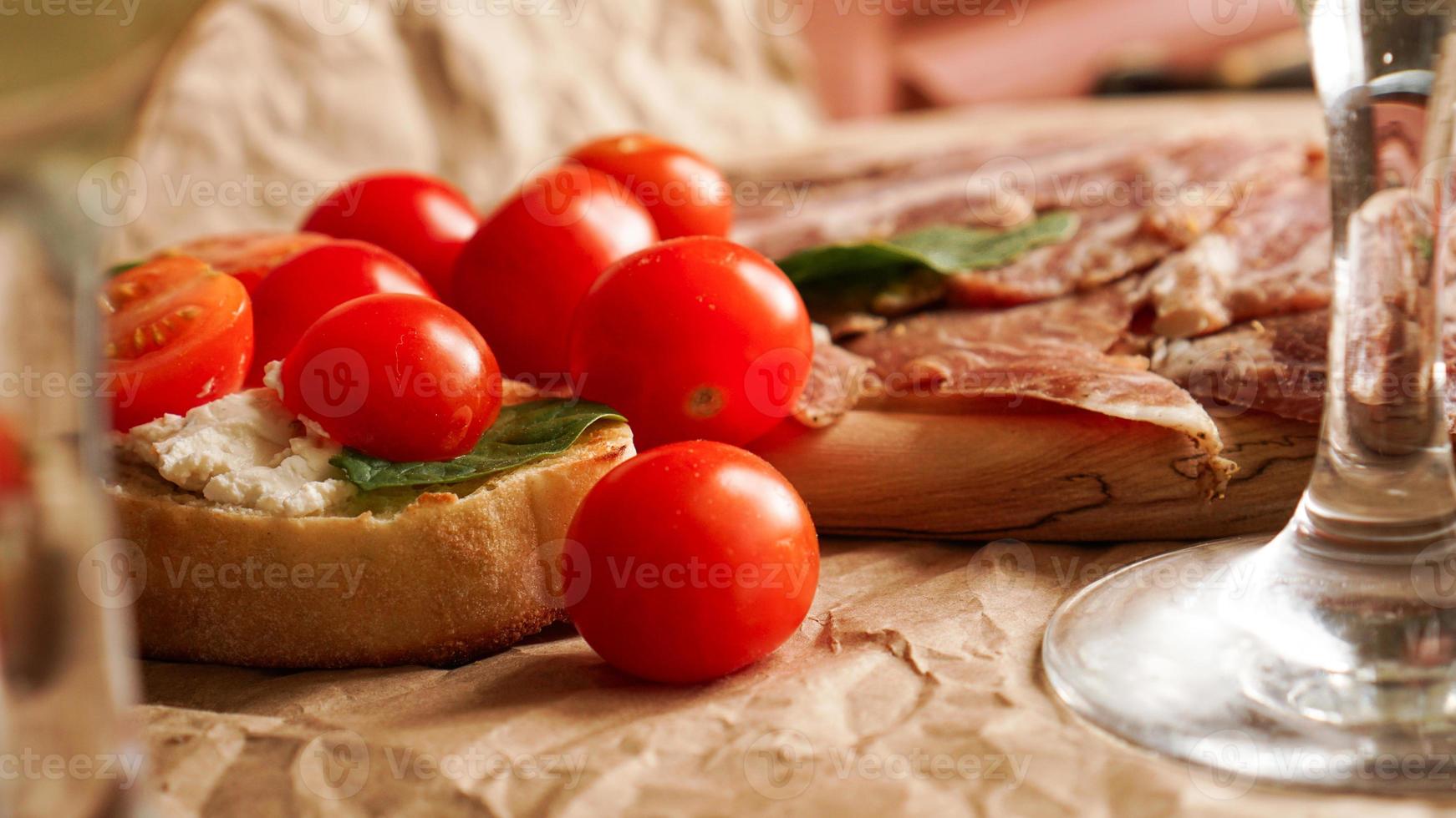 bruschetta com tomate cereja. copo de vinho, aperitivo italiano. foto