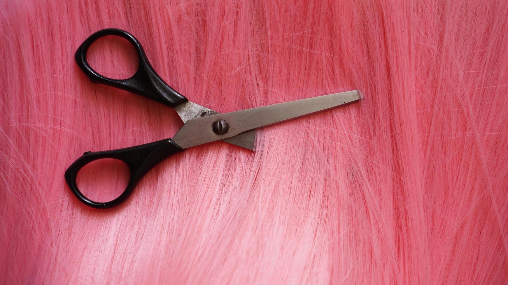 peruca e tesoura - peruca rosa - fundo penteado foto