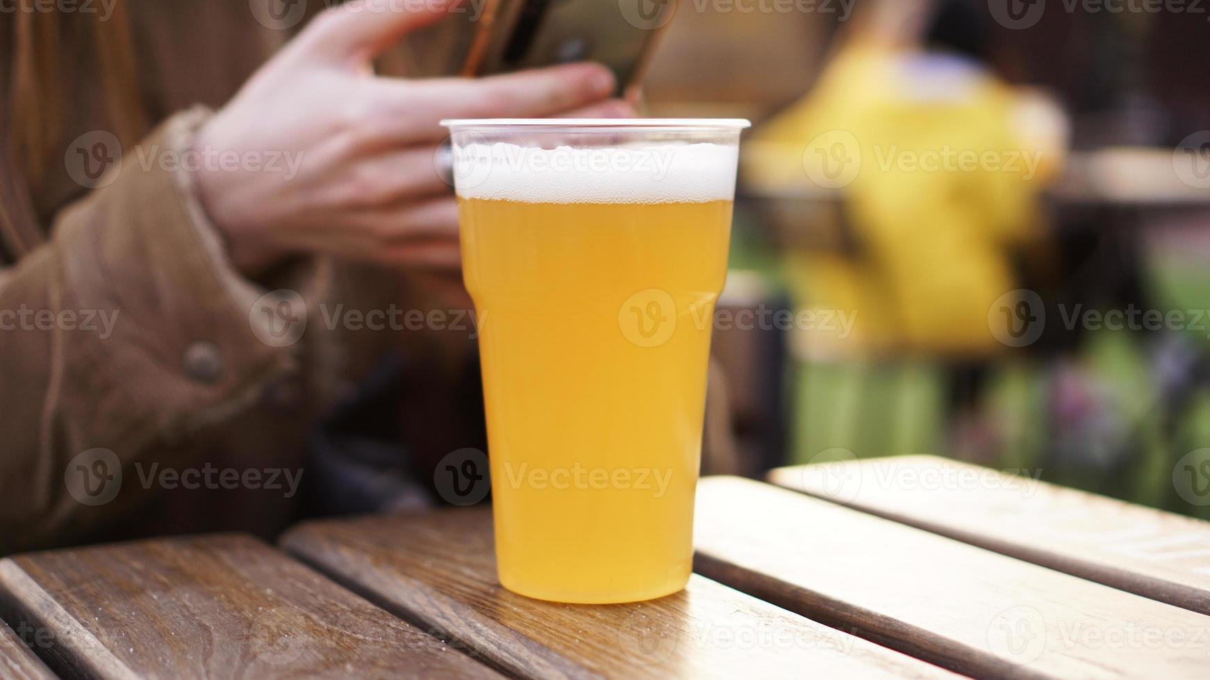 cerveja light em copo de plástico. garota bebendo cerveja na praça de alimentação foto