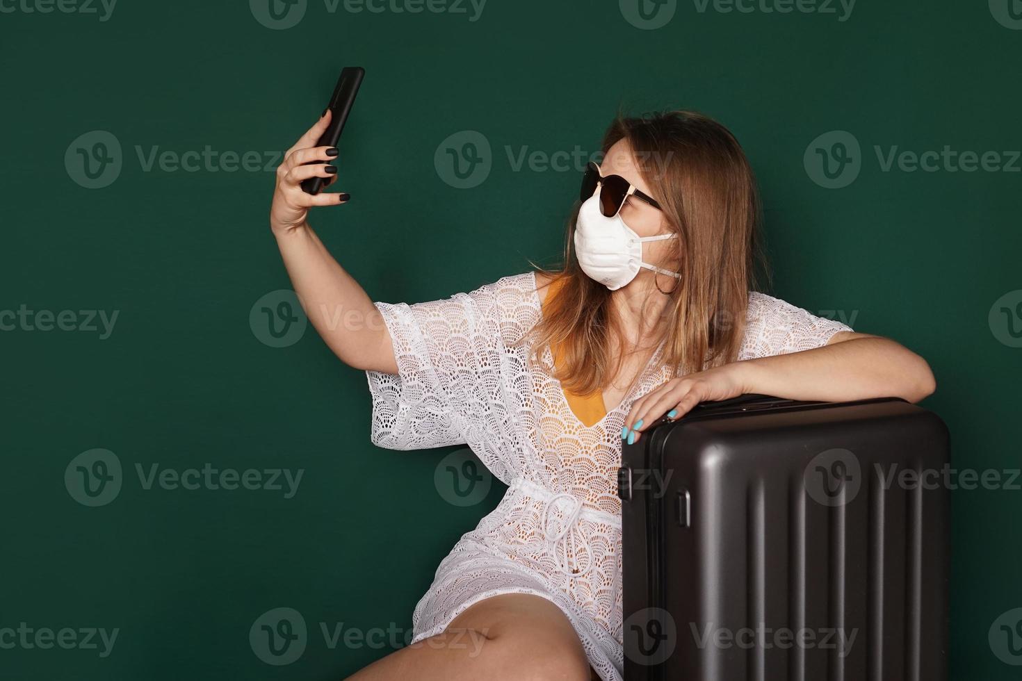 linda garota com máscara médica no rosto tirando selfie foto