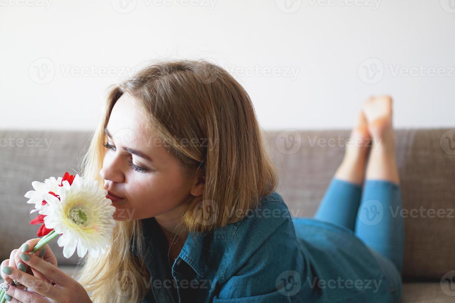 jovem atraente cheirando buquê de flores foto