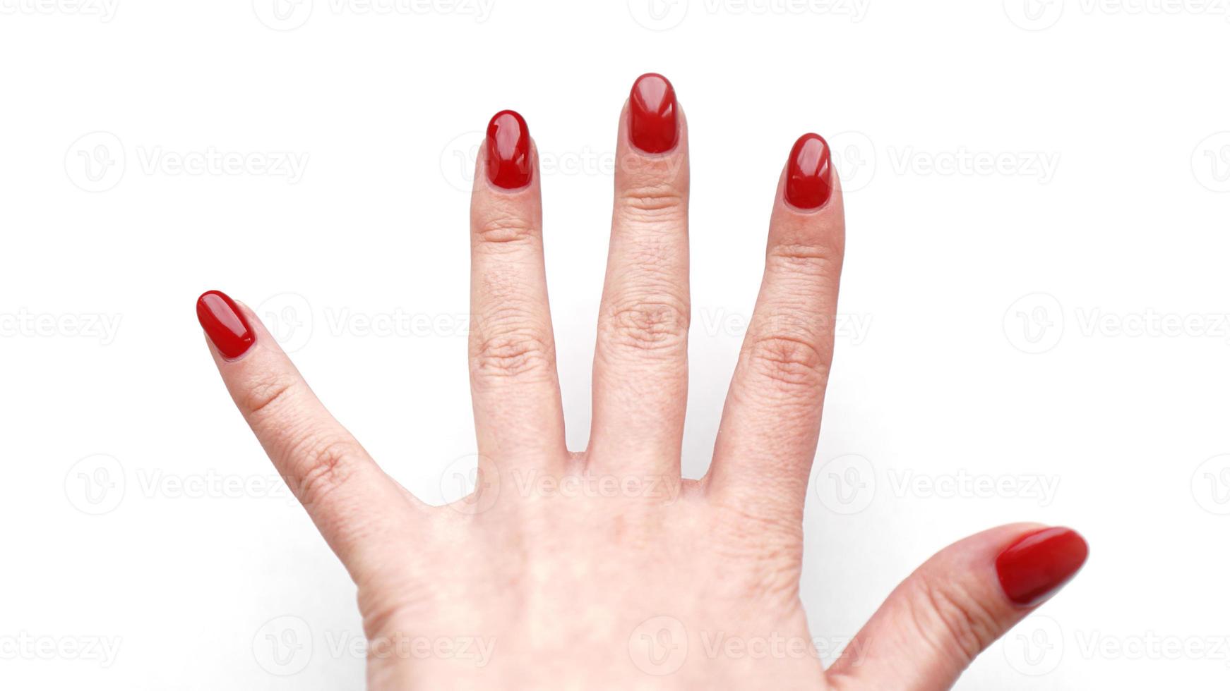 linda mão feminina com manicure e unha vermelhas foto