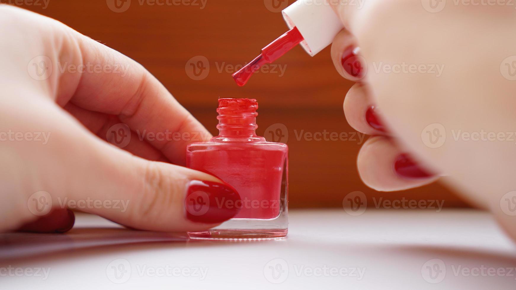 manicure. lindas unhas de mulher bem cuidadas com esmalte vermelho foto