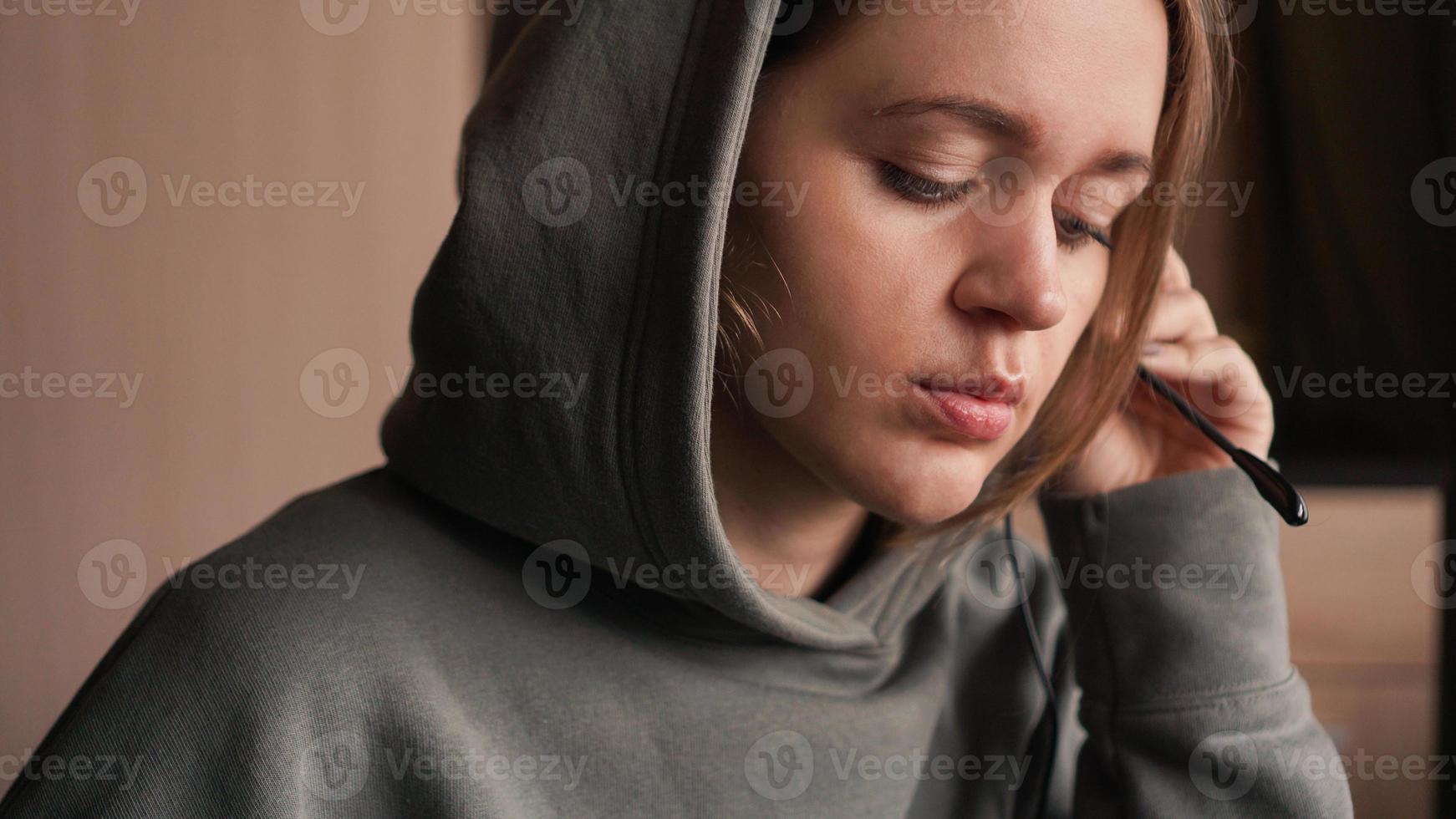 retrato de uma jovem com um capuz e um fone de ouvido. Central de Atendimento foto