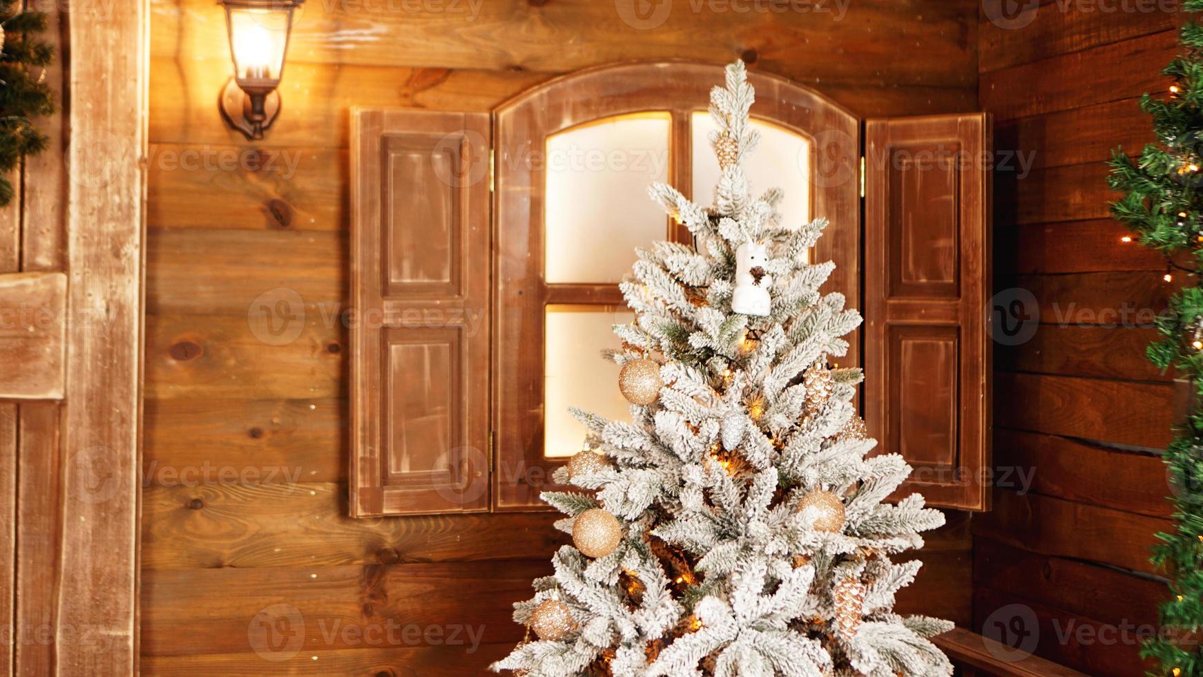 árvore de natal prateada com bolas douradas em fundo de madeira foto