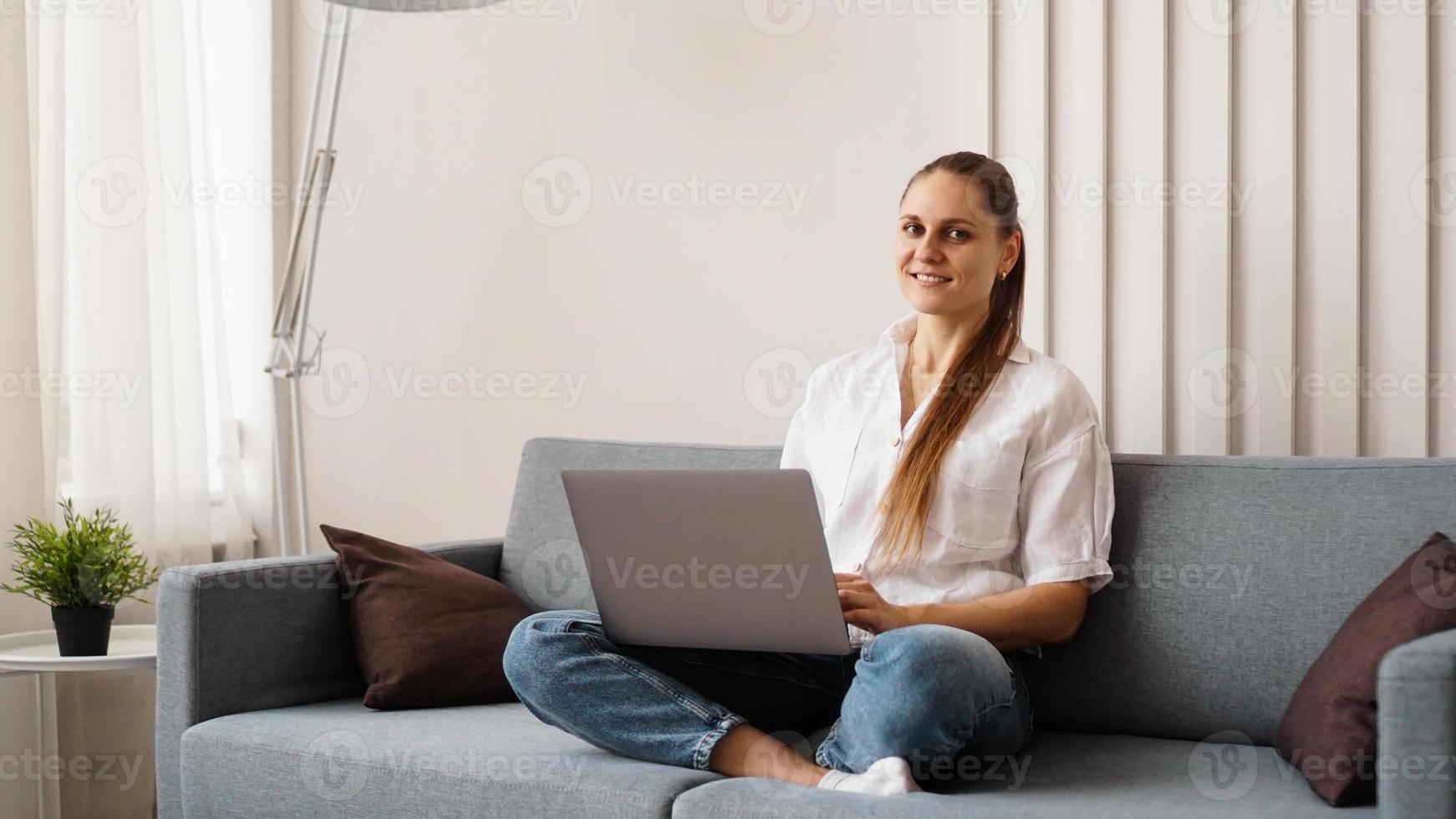 mulher trabalhando em um laptop em casa ou estudante estudando em casa foto