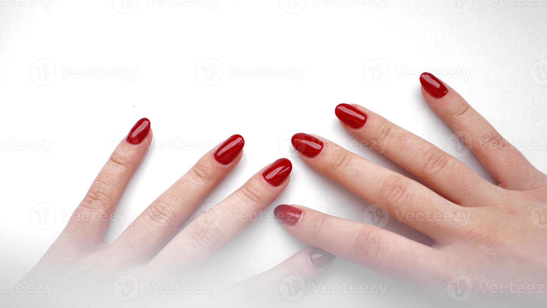 linda mão feminina com manicure e unha vermelhas foto