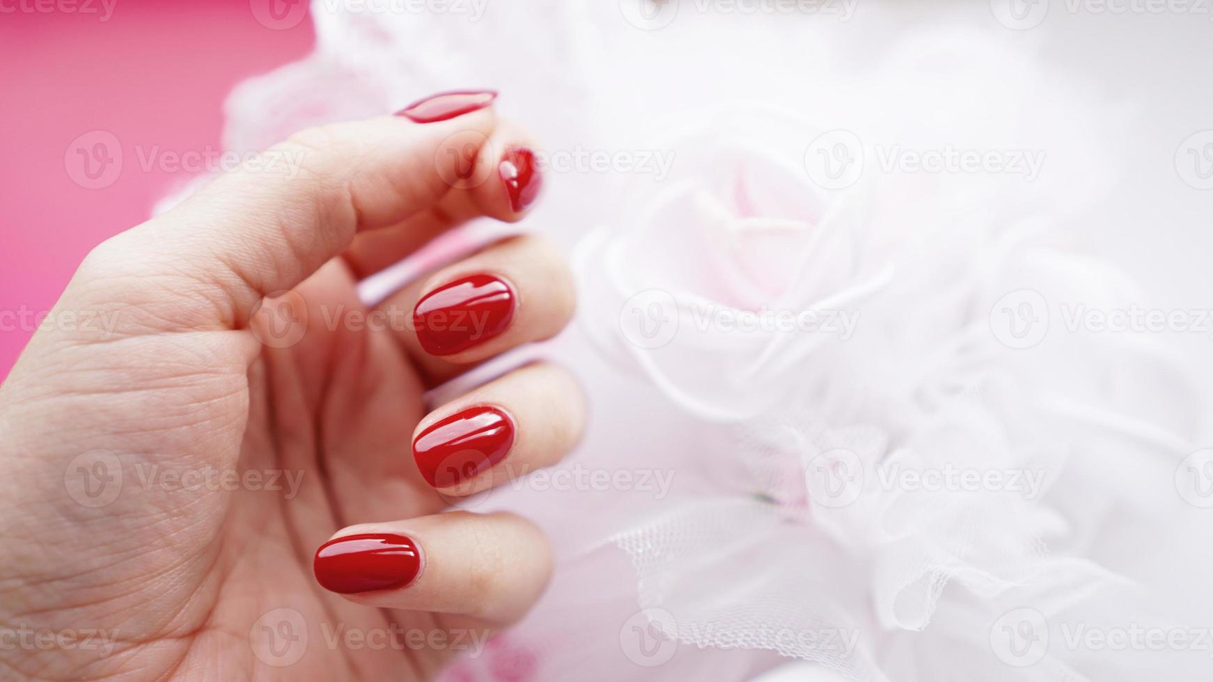 linda mão feminina com unhas vermelhas foto