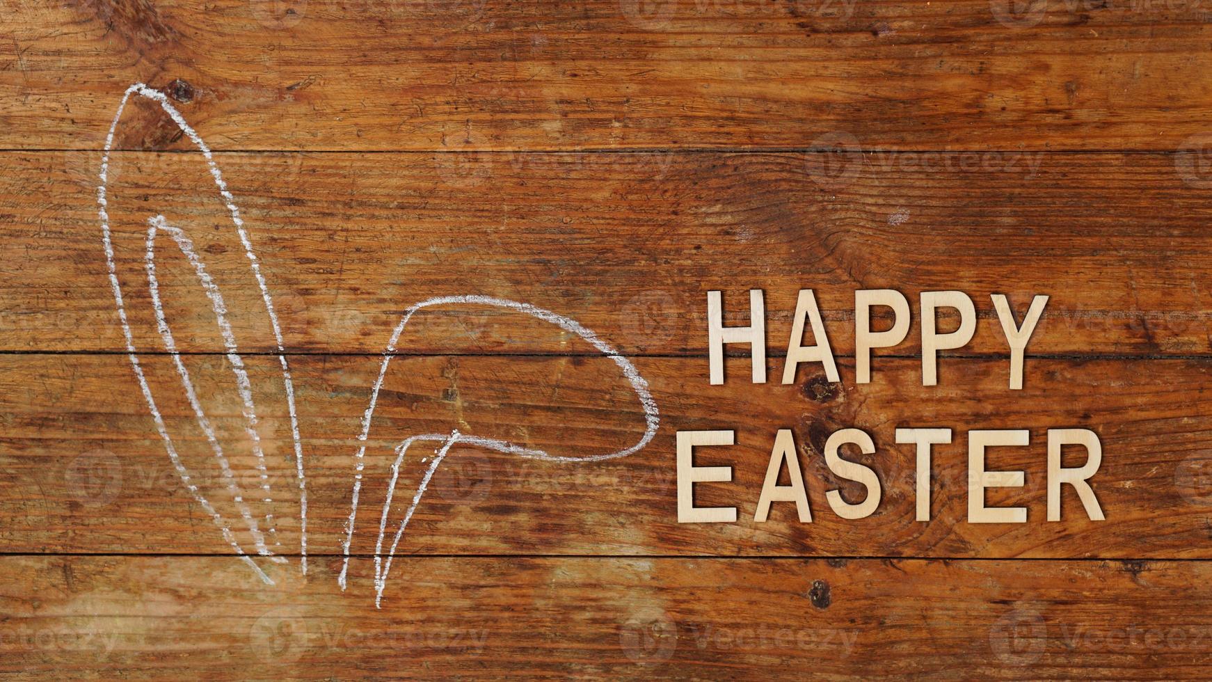 orelhas desenhadas a giz. orelhas de coelho em um fundo de madeira. Feliz Páscoa foto