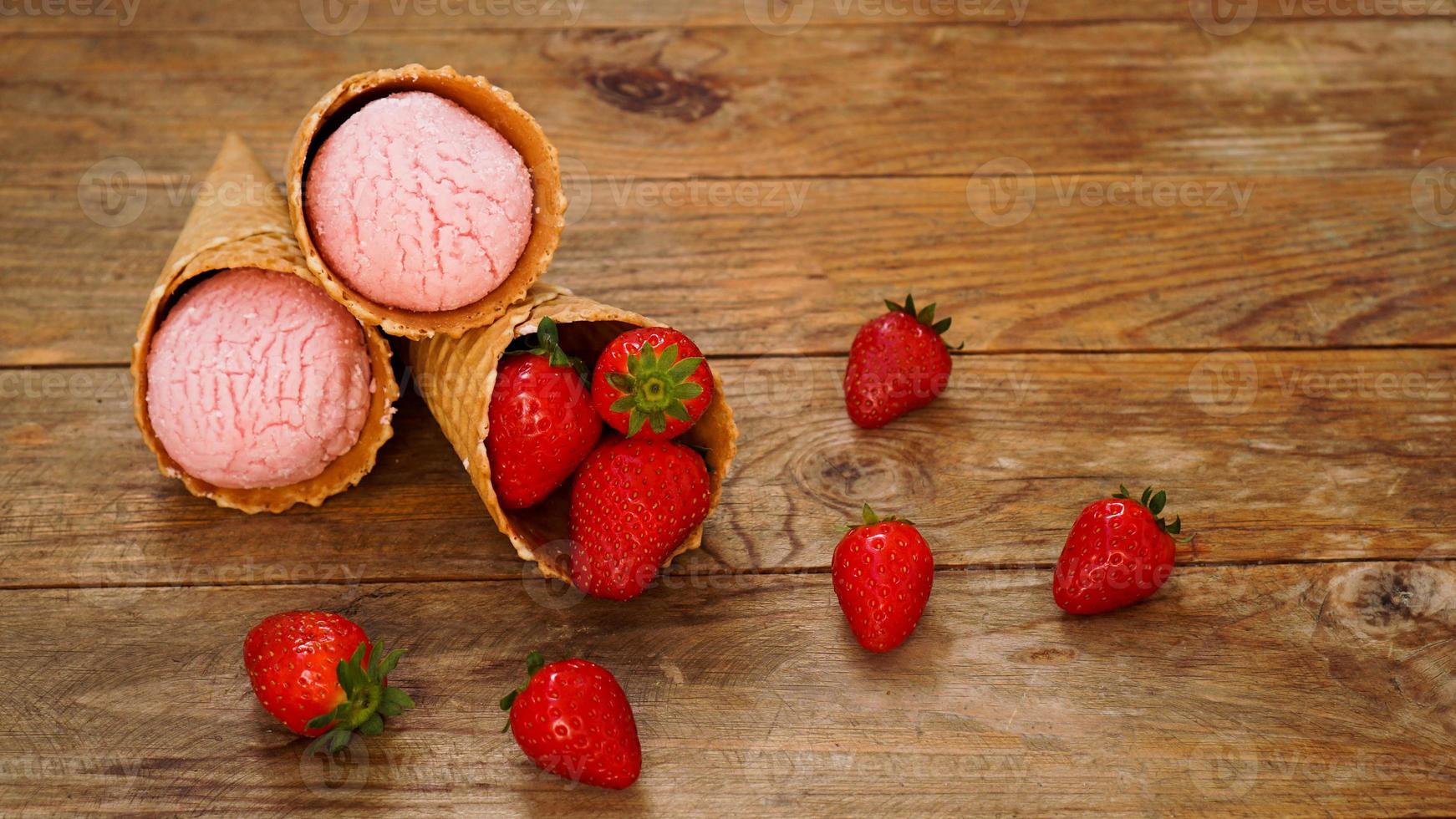 sorvete de morango em uma casquinha de waffle. frutas vermelhas e bolas de sorvete foto