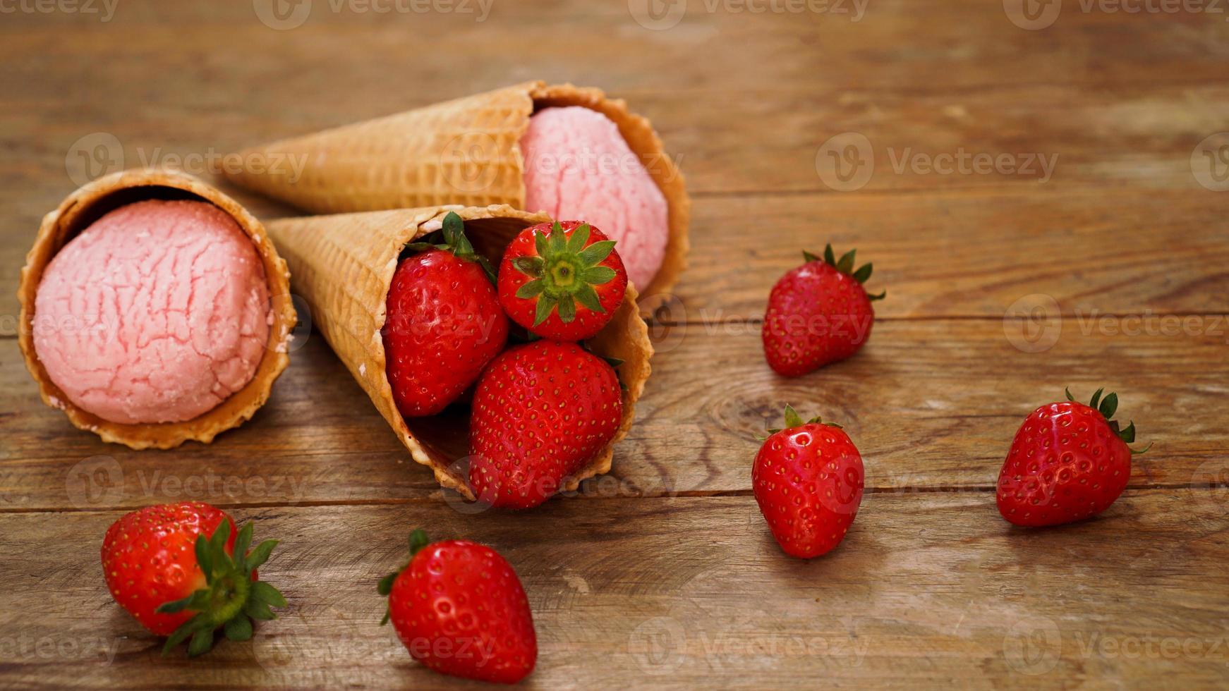 sorvete de morango em uma casquinha de waffle. frutas vermelhas e bolas de sorvete foto