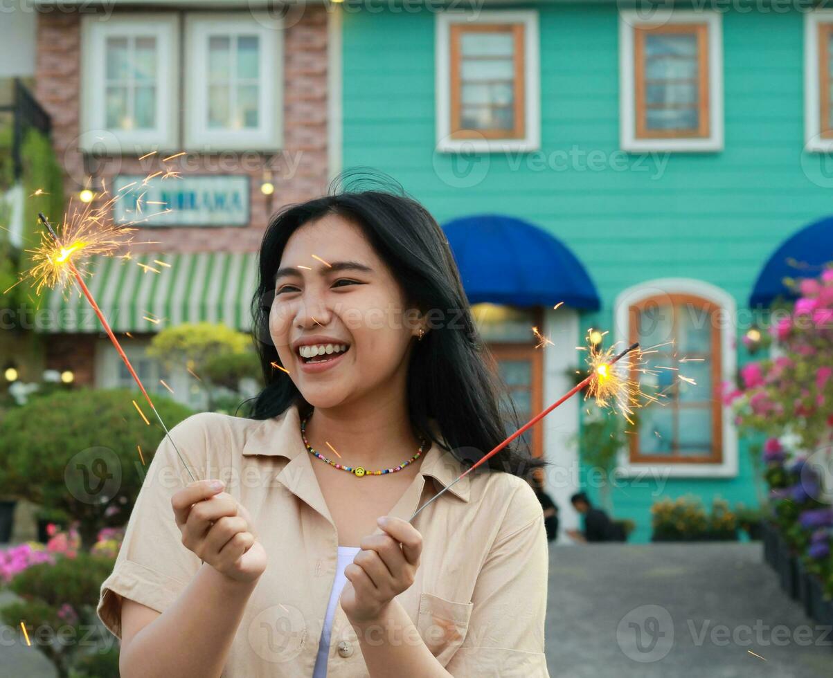 feliz jovem ásia mulher segurando diamante a comemorar Novo ano véspera dentro vintage casa quintal, ao ar livre jardim foto