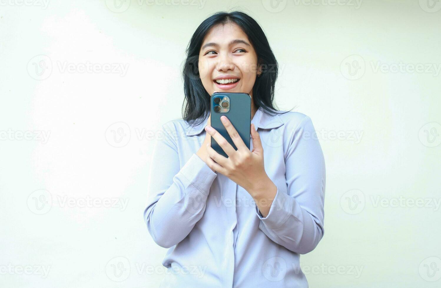 retrato do pensativo positivo ásia jovem o negócio mulher segurando célula telefone pensando plano com sonhadores tem, sonhando acordado fêmea vestem formal camisa usando social meios de comunicação isolado sobre branco fundo foto