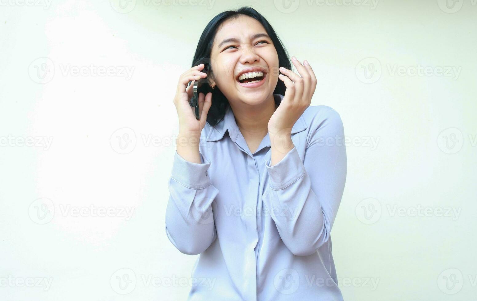 retrato do em êxtase ásia jovem o negócio mulher rindo Falando em Móvel telefone, bem sucedido fêmea levantando braço Veja longe alegria, vestem formal escritório camisa em pé sobre isolado branco fundo foto