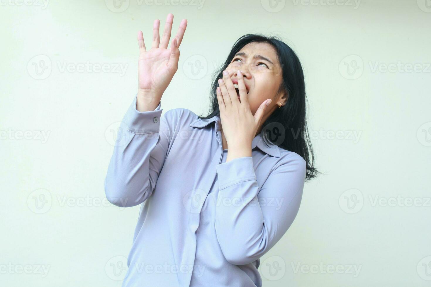 chocado ásia jovem bonita o negócio mulher assustado olhando acima, cobertura aberto boca e levantando braço, vestindo formal camisa em pé sobre isolado branco fundo foto