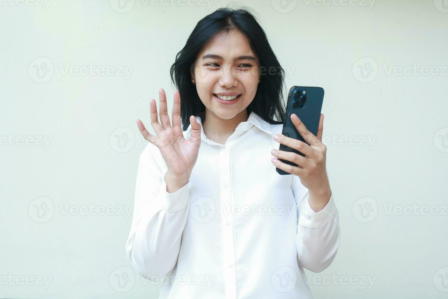 imagem do sucesso calma ásia jovem o negócio mulher empreendedor levantando Palmeiras dizer Oi gesto segurando Smartphone vestem branco terno camisa, em pé confiante vídeo chamando sem fio comunicação foto