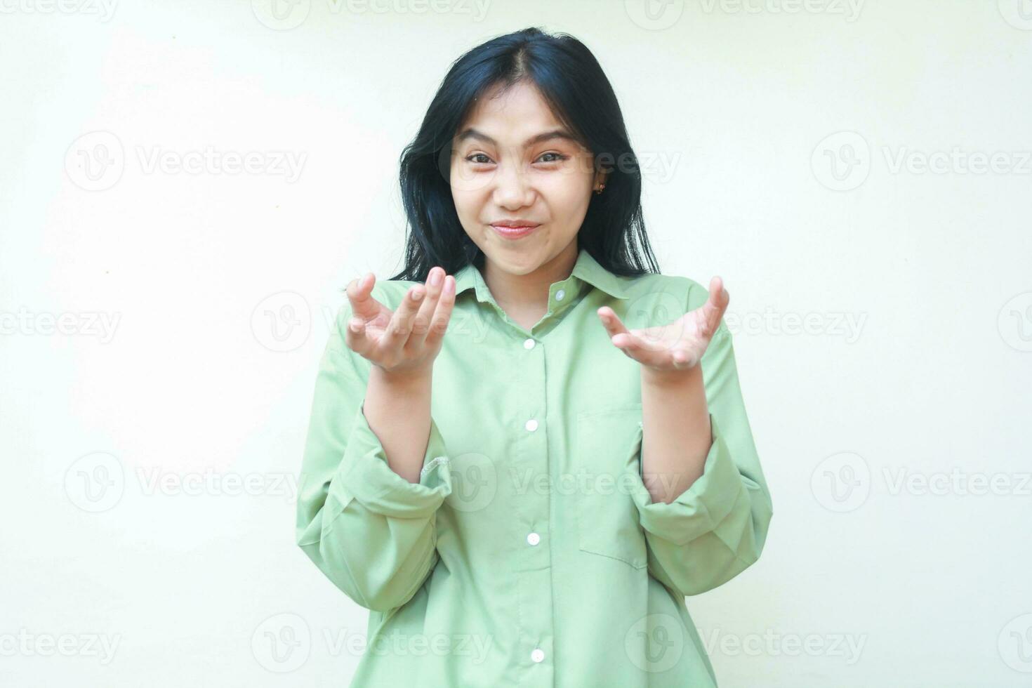 satisfeito ásia mulher com Sombrio cabelo levantando Palmeiras frente às Câmera sorridente Faz apresentando gesto vestem verde camisa em pé isolado branco fundo foto